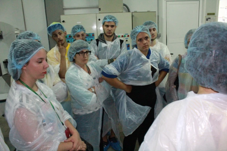 a group of people standing in a room wearing surgical gear