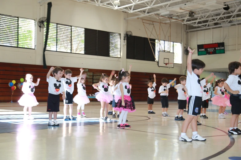 children in dress up costumes and their coach performing ballet