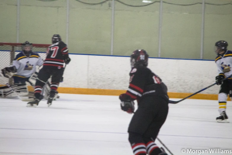 the ice hockey player is making a s at the goalie