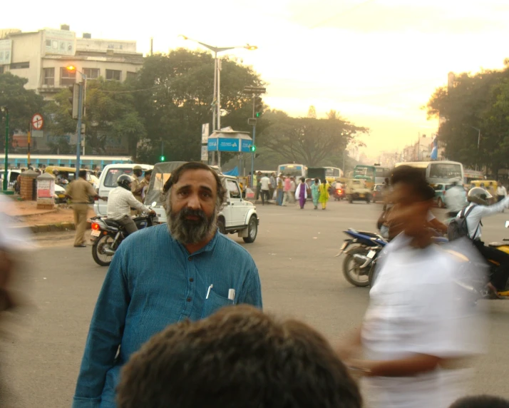 a man is standing near others riding motorcycles