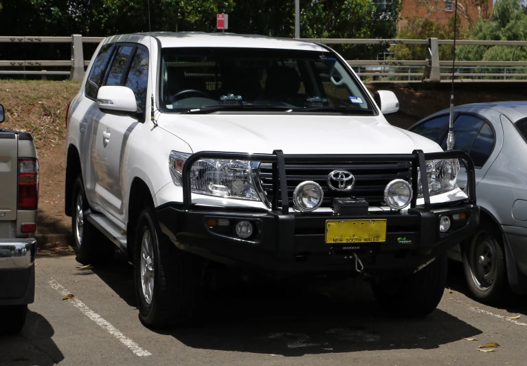 a white truck parked next to other cars