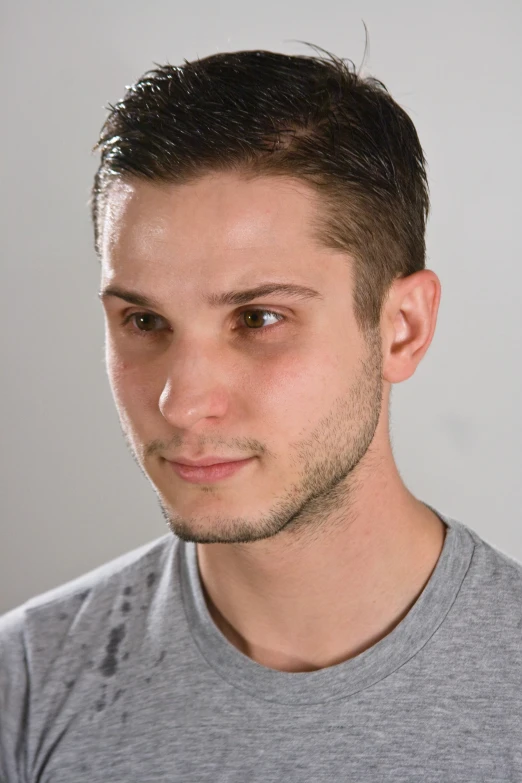 a man is looking towards the camera, wearing a gray shirt