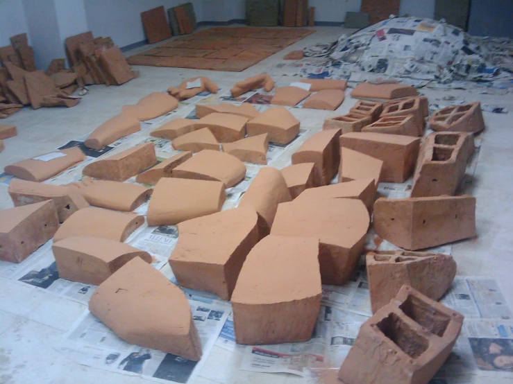 several clay like blocks being made on a cloth covered floor