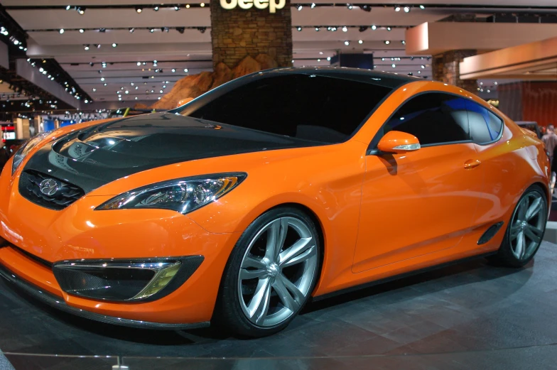 a large orange car sitting on top of a show floor