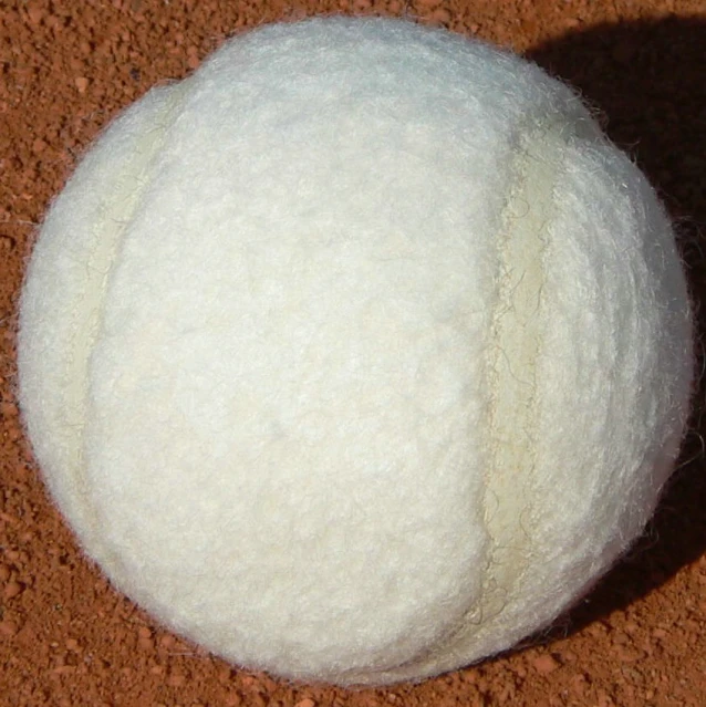 the ball is white and on the dirt