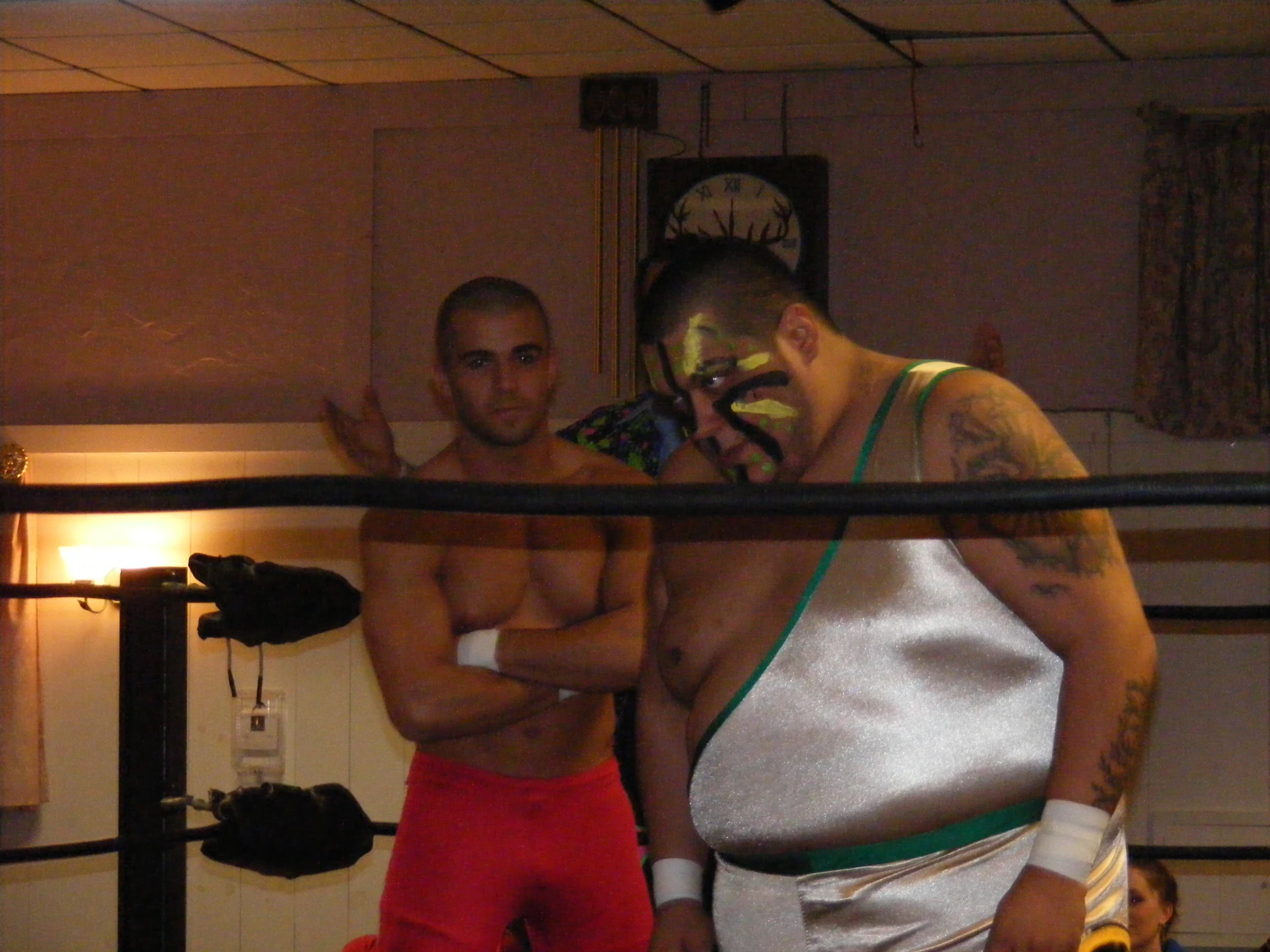 two men are posing for the camera in an empty room