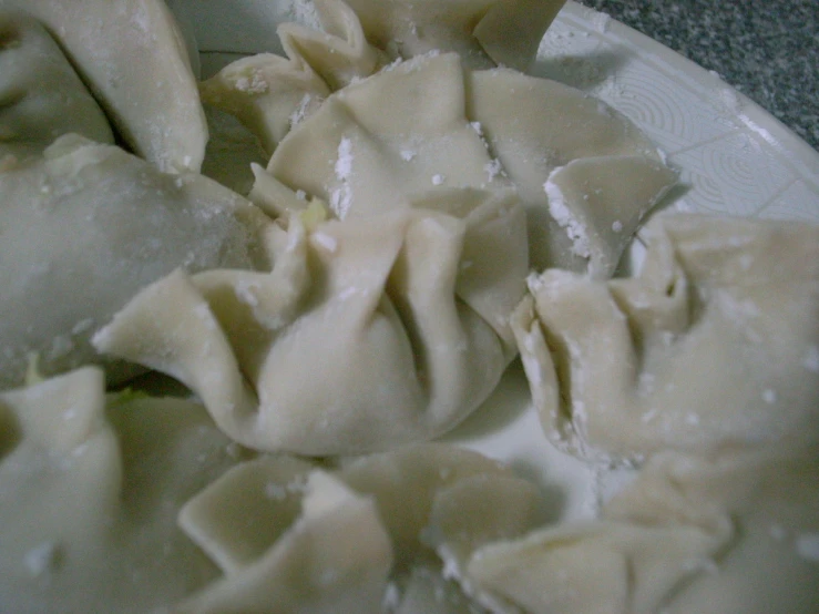 a white plate topped with dumplings and cheese