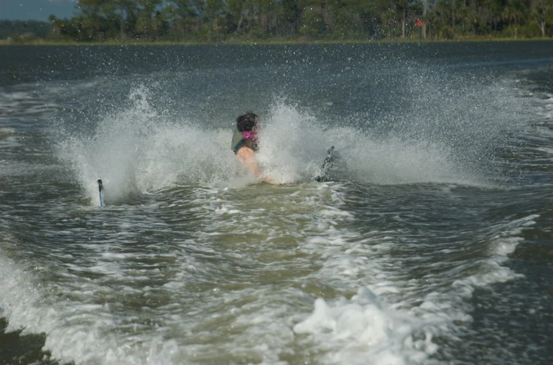 a woman skiing in the water splashing out of her skis