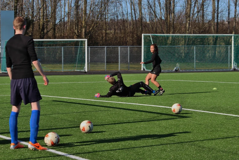 young people playing soccer in the park, on a sunny day