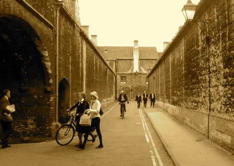 people are walking down an alley next to bicycles