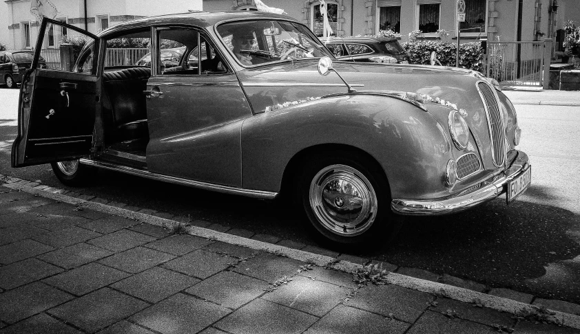 a classic car parked in the city with no people around