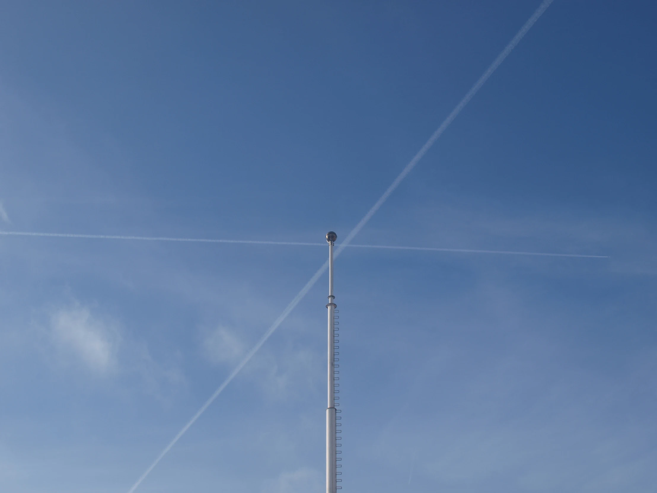 two airplanes flying in the sky above one another