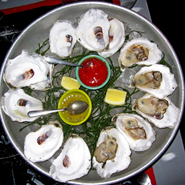 an assortment of oysters on ice with red sauce