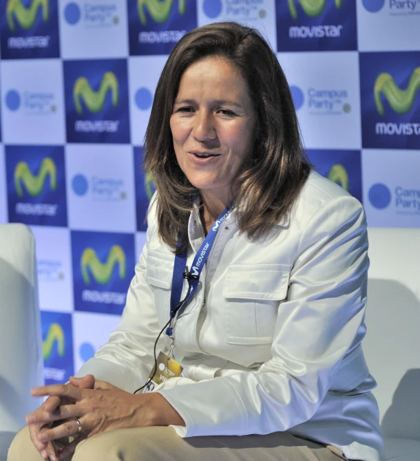 an older woman in a white jacket is sitting on a white couch