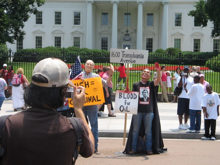 a man holding a sign with a protest outside of the white house