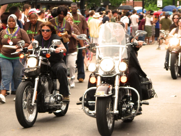 a parade with a few motorcycles in the road