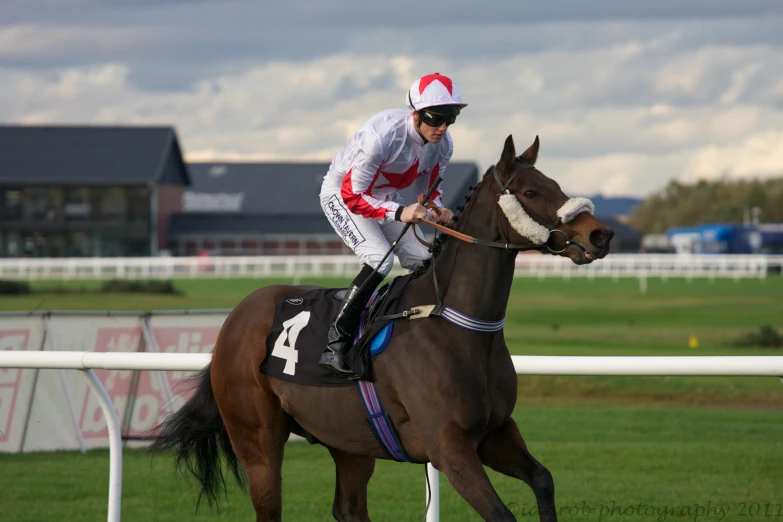 a jockey on a horse riding across a track