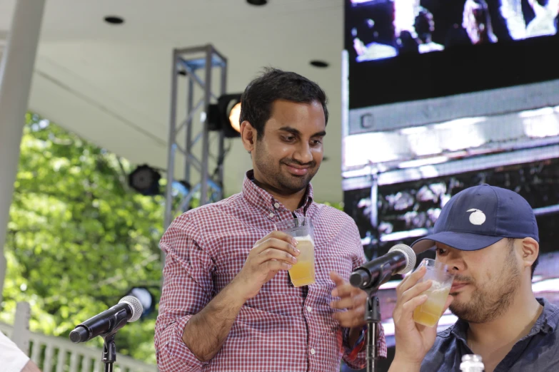 two men are eating, drinking and eating soing while standing