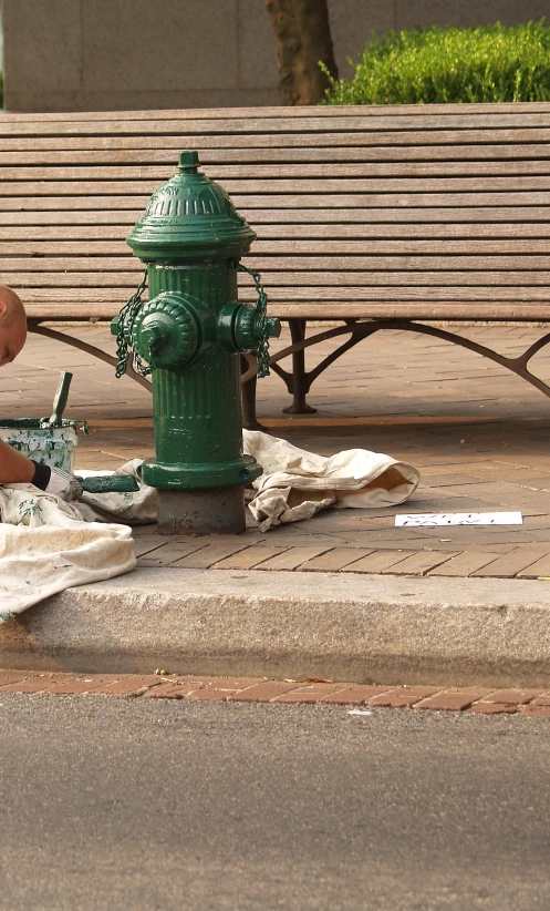 a man cleaning a fire hydrant on the side of the road