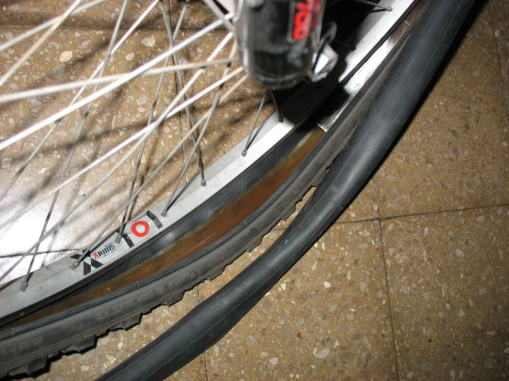 a wheel that has spokes sitting next to another wheel on a sidewalk