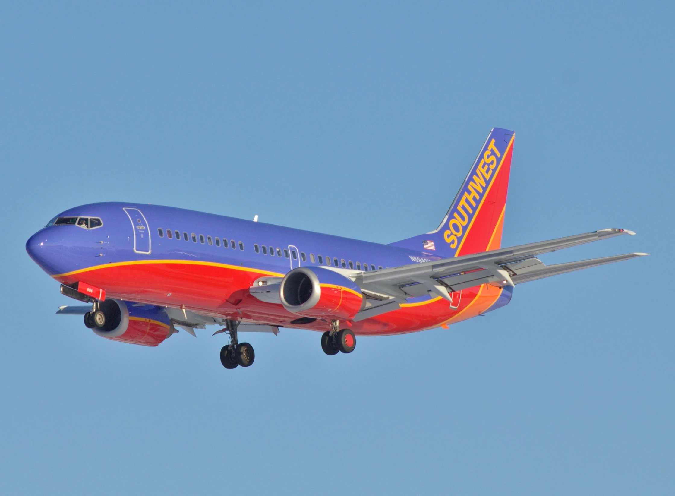 a plane flying in the sky with it's landing gear down