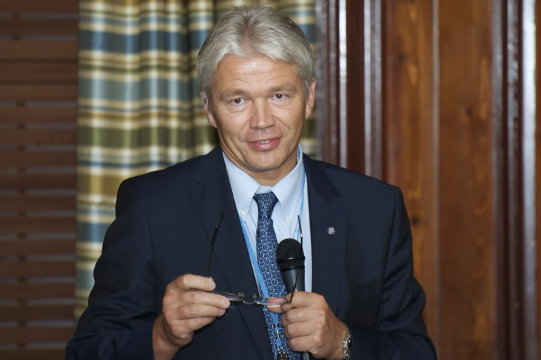 a man in a suit holds scissors to his hands