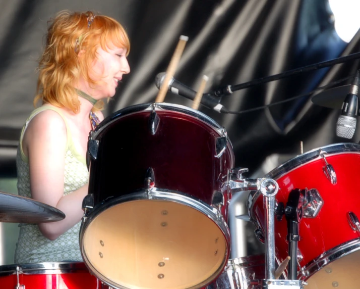 a woman in a short dress plays the drums