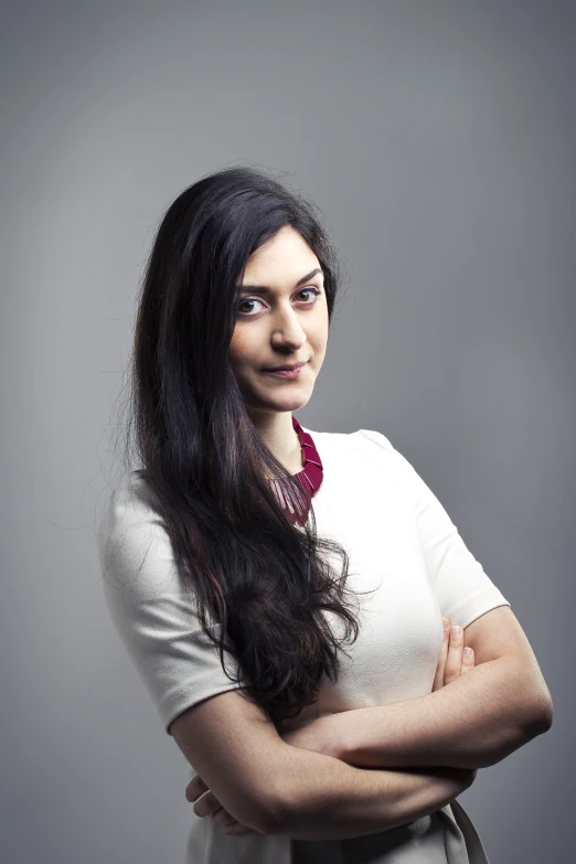 a woman wearing a white shirt and tie, with long dark hair