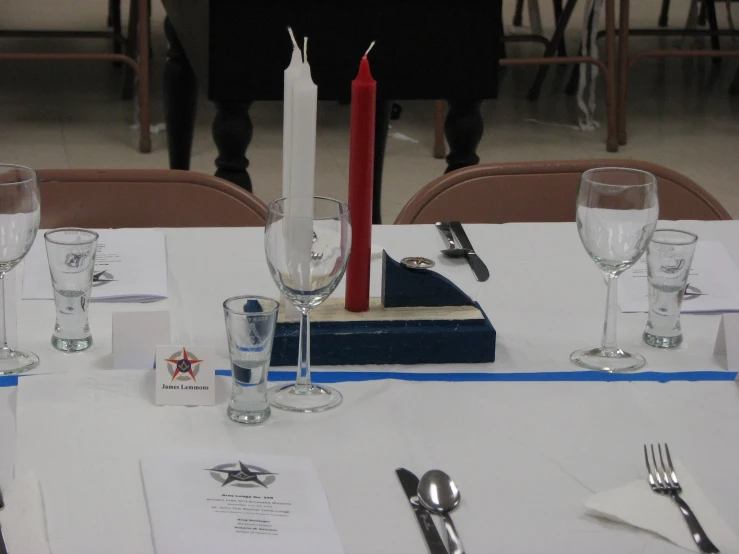 a table with silverware and a red candle on it