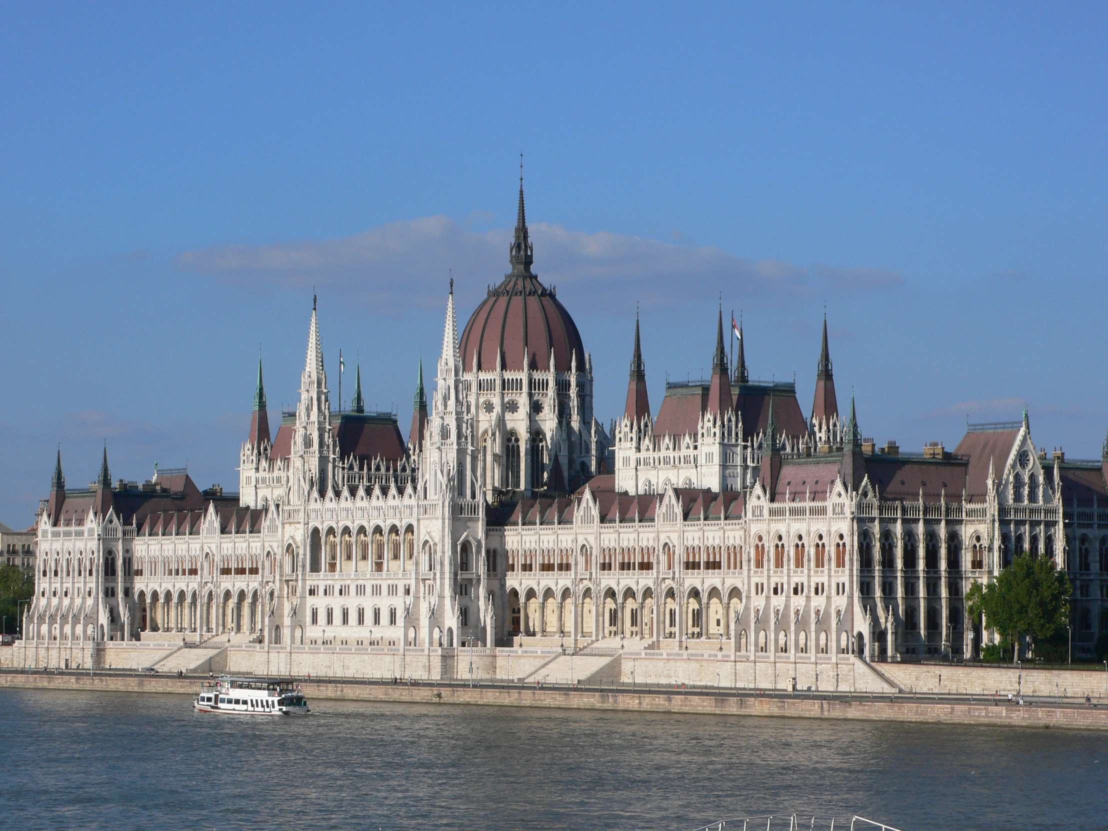 a building with spires on the side of the river