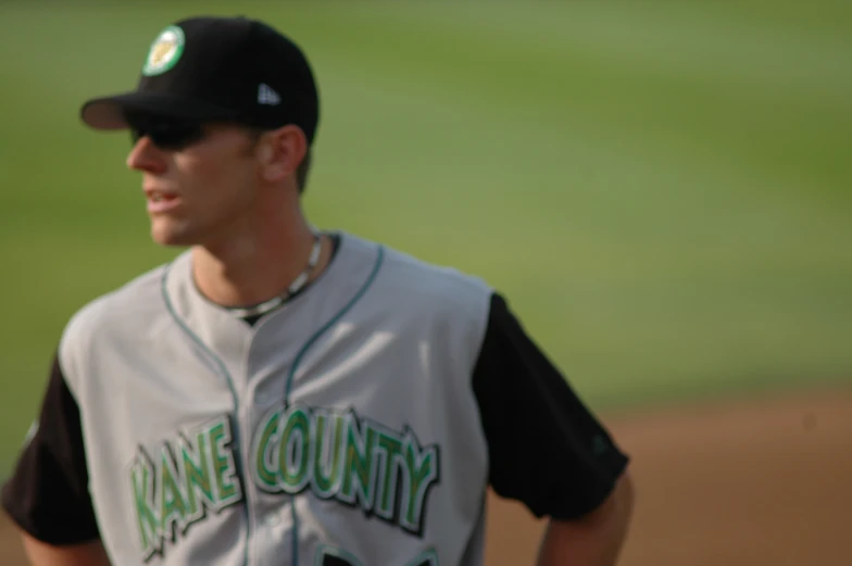 baseball pitcher at a green field looking down