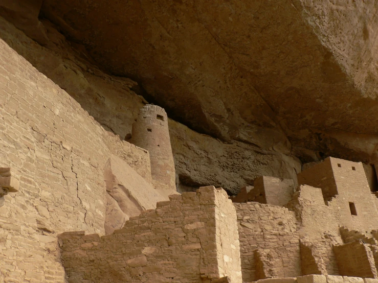 several tall stone buildings sitting below a mountain