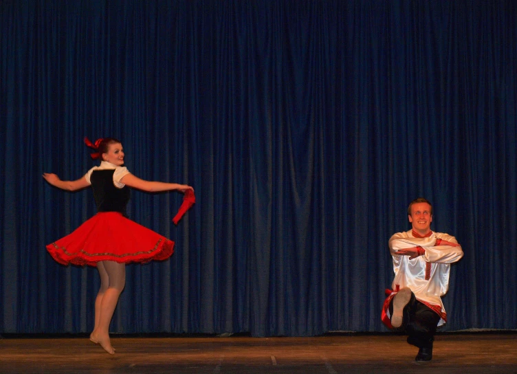 two dancers, one holding onto a string while the other holds on to her leg