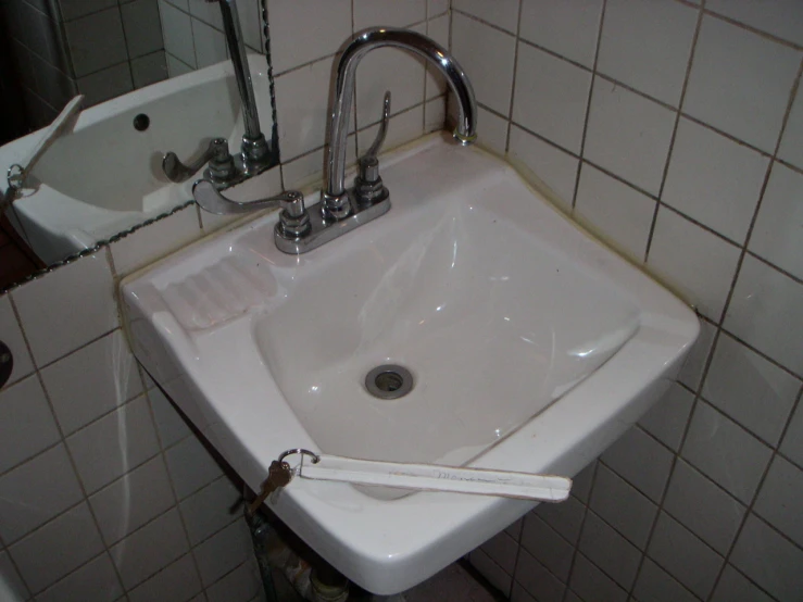 a bathroom with a white sink next to a wall mirror