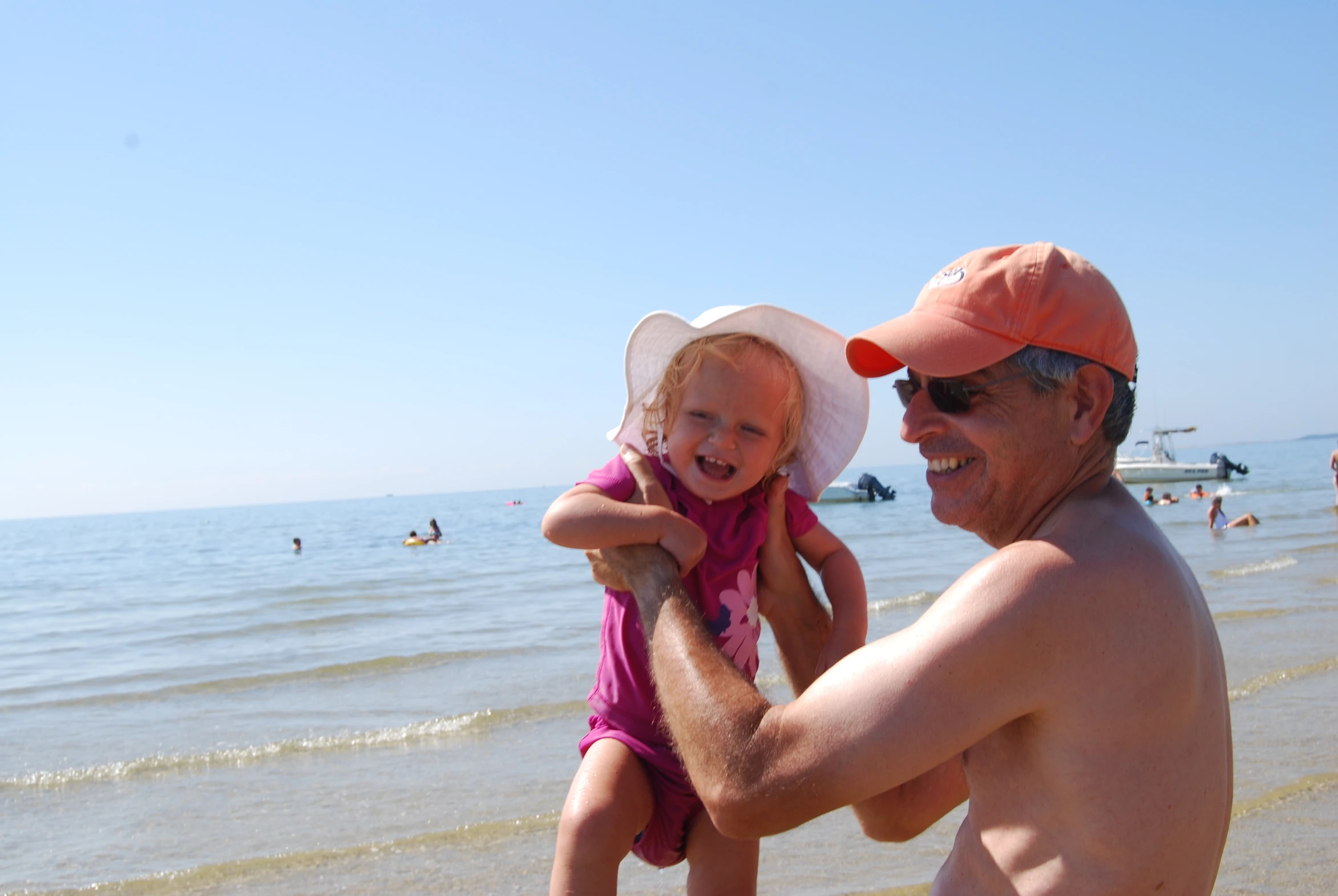 a man holding a little girl on the beach