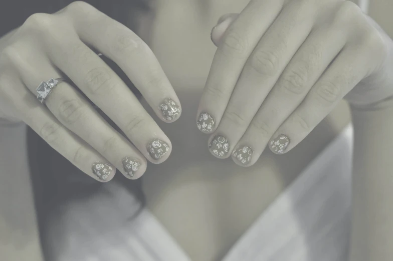 the woman has her nails decorated with white diamonds