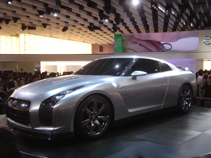 the car is sitting on display in front of an audience