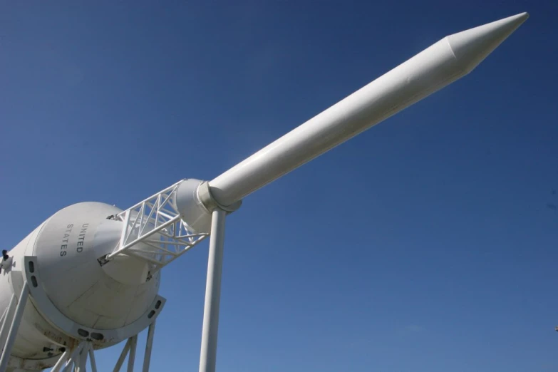 an airplane on a runway next to a wind turbine