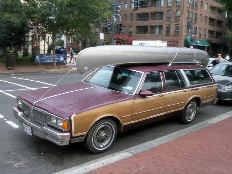 the car is parked on the side of the road with a canoe strapped to its roof