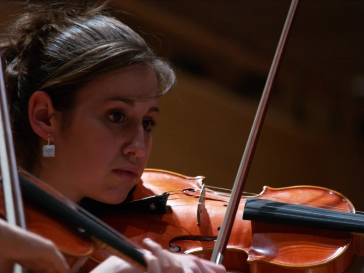 the violin is being played by a woman in a dress