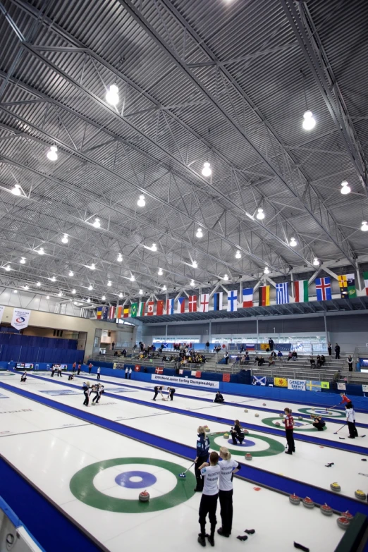 some people are standing on a big curling rink