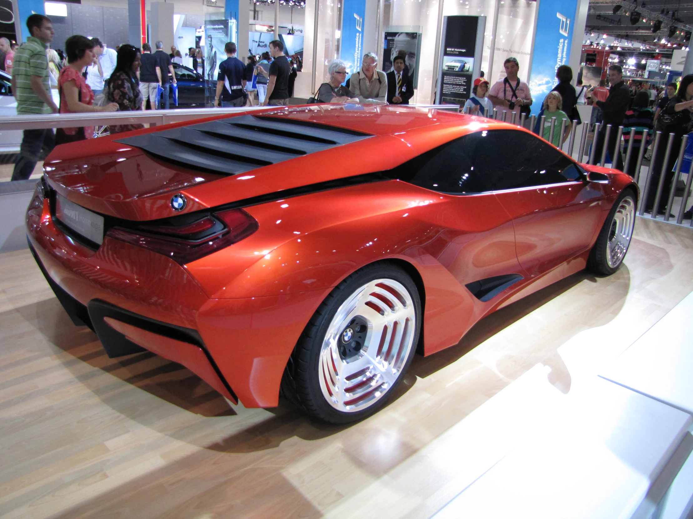 a very cute looking orange sports car on display