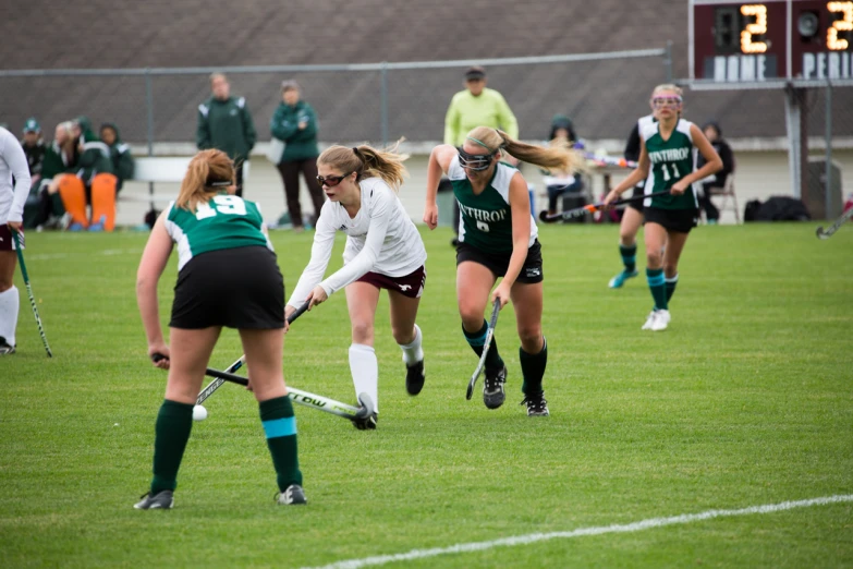 some women playing soccer on a field with many people