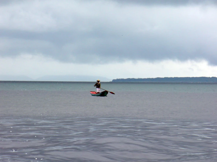 a man riding on a surfboard across a big lake