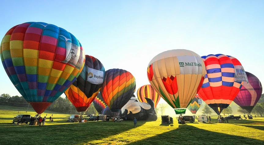 many colorful  air balloons are on display at an outdoor festival