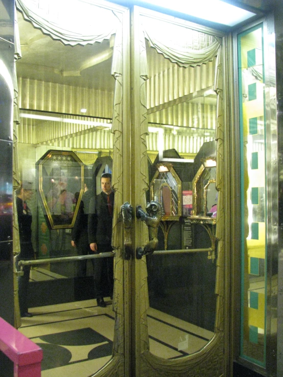 people look into a mirrored room with a large mirror