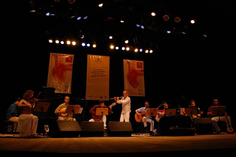 an orchestra group with people playing instruments on stage