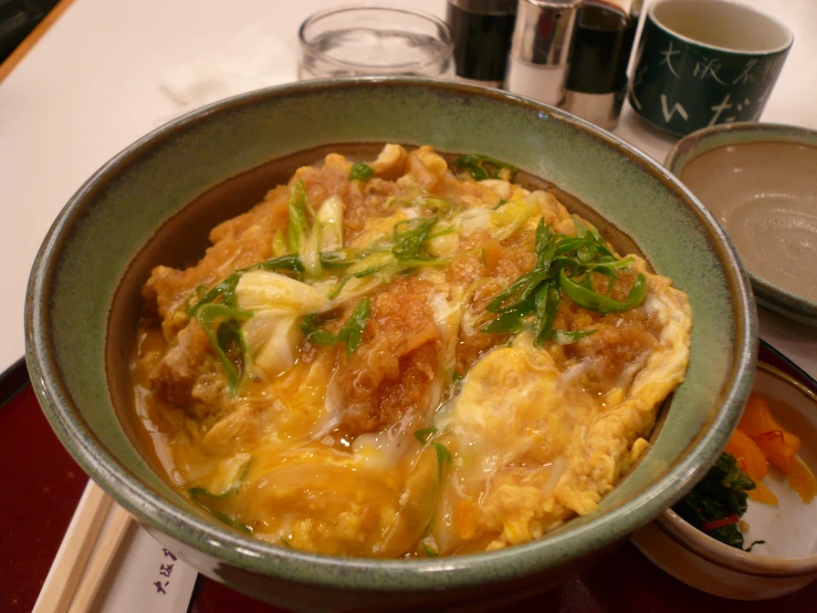 a bowl filled with asian food on top of a table