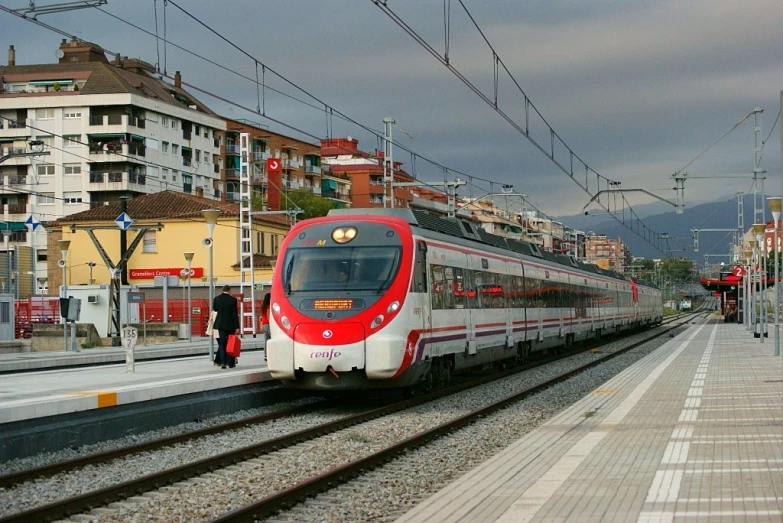 the passenger train is passing by an empty area