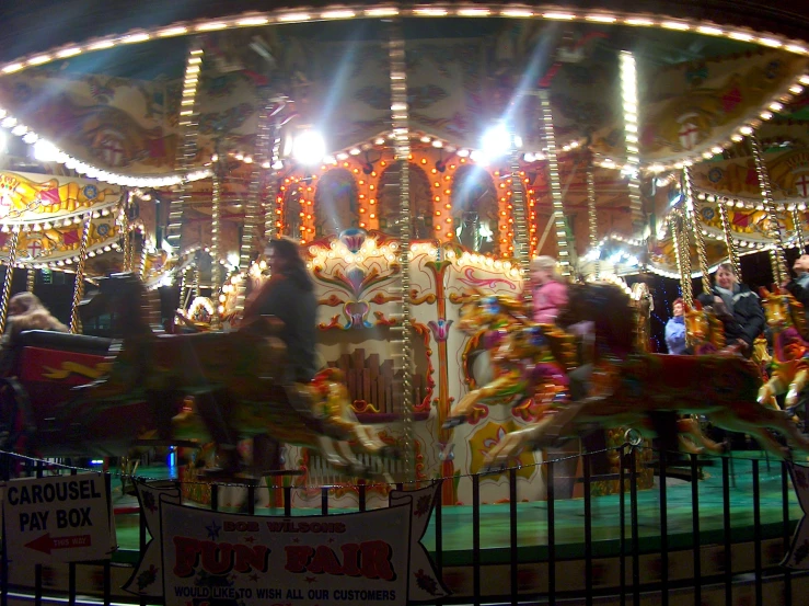 a carousel with the lights on and people riding it